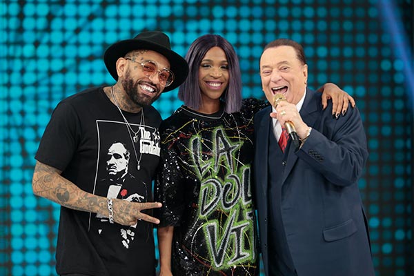 Dj Hadji, Karol Conka e Raul Gil aparecem sorrindo lado a lado enquanto participam do Programa Raul Gil