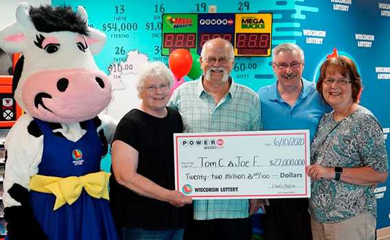 Foto: Cook e Feeney, ao lado de suas esposas, recebendo o cheque da loteria. Crédito: Wisconsin Lottery/Divulgação