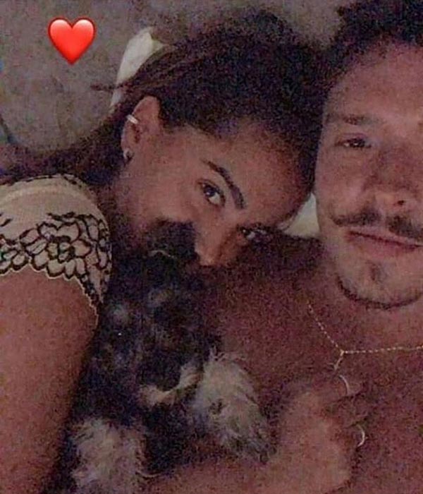 Anitta e Ronan Souza deitados na cama