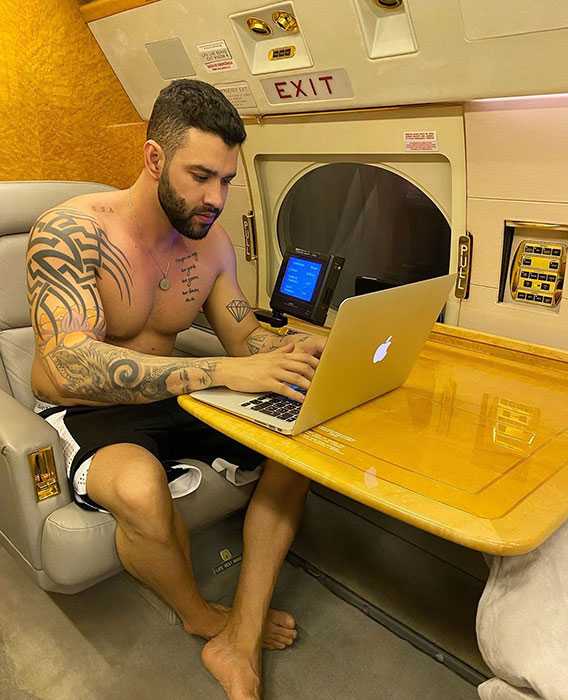 Gusttavo Lima sem camisa mexendo no computador