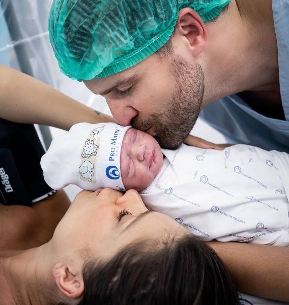 Flavia Viana e o marido, Marcelo Zangrandi, beijando o filho após o nascimento