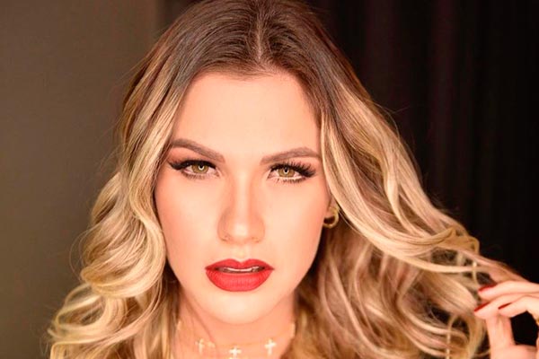 Andressa Suita posa maquiada e de batom vermelho