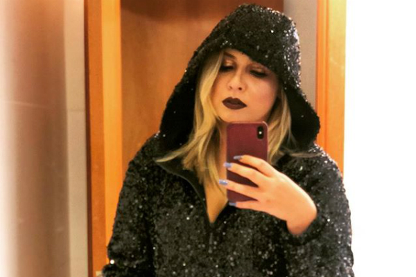 Com capuz e jaqueta preta, Marília Mendonça tira foto em frente ao espelho