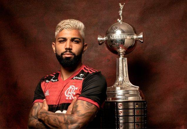 Gabigol. do Flamengo, de braços cruzados com a taça da Libertadores em segundo plano