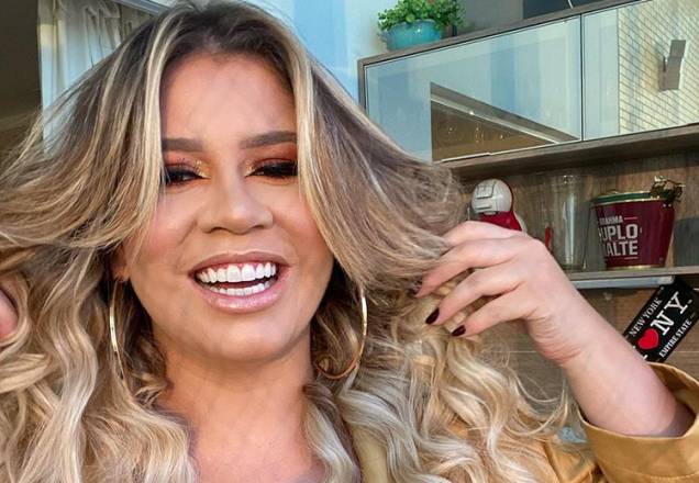 Marília Mendonça posa na piscina e deixa marquinha à mostra