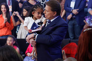 Silvio Santos entra no palco distribuindo chocolate
