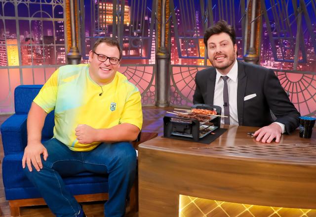 Da esquerda para a direita, Darlan Romani posa ao lado de Danilo Gentili no palco do The Noite