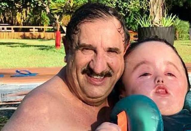 Ratinho posa sorrindo dentro da piscina ao lado do neto Noah