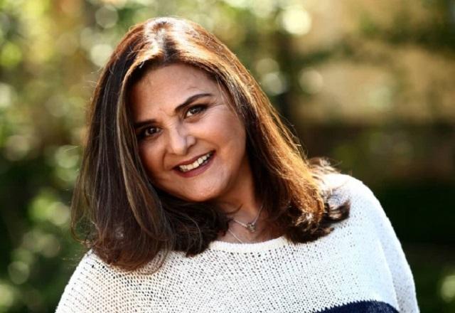 Atriz Elizangela posa no jardim sorrindo