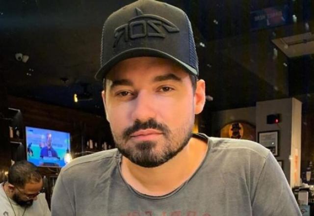O cantor Fernando Zor posa com camisa cinza e boné preto
