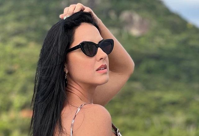 Graciele Lacerda posa de costas com a mão no cabelo
