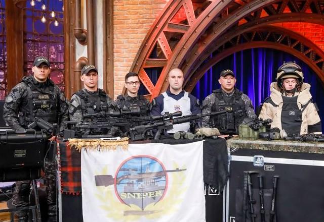 Capitão Pavão, Soldado Gustavo e os convidados do GATE posam para foto.