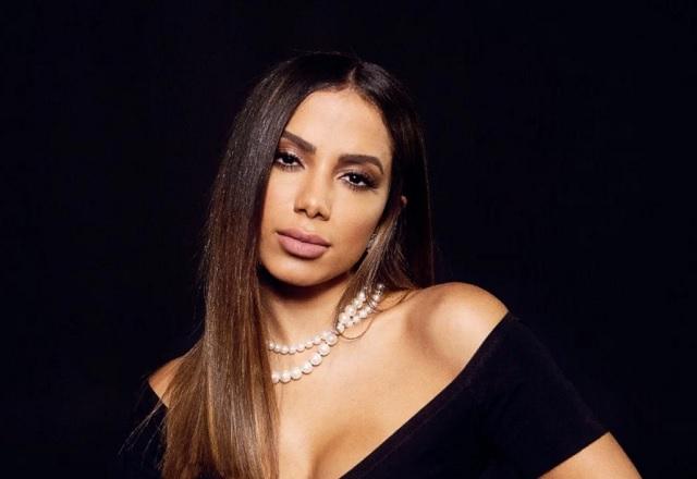 Anitta posa com cara série em frente a fundo preto
