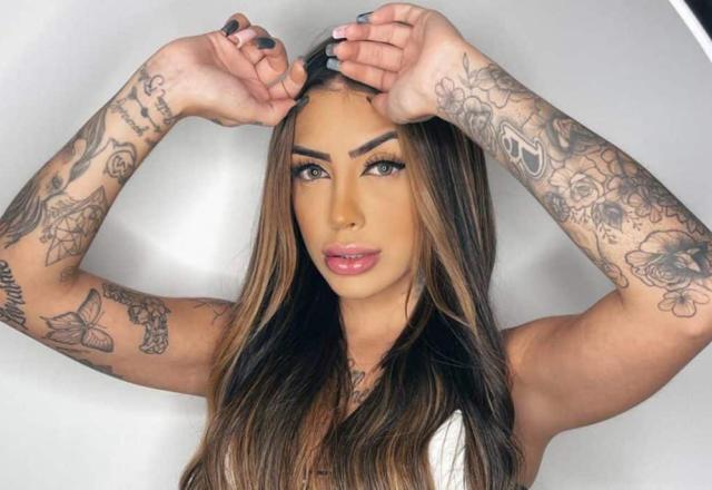 A cantora Mirella posa com blusa branca e os braços para o alto