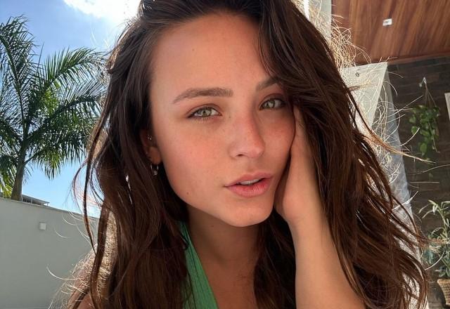 Larissa Manoela tira selfie na praia com a mão no rosto