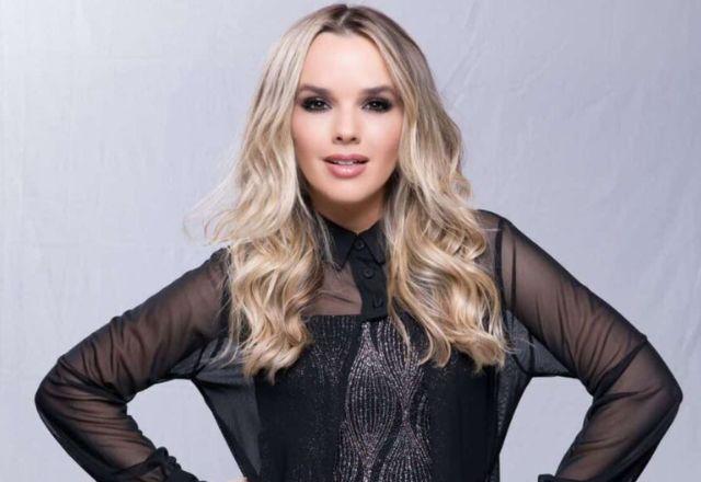 Cantora Thaeme posa para foto usando uma blusa preta e cabelos soltos