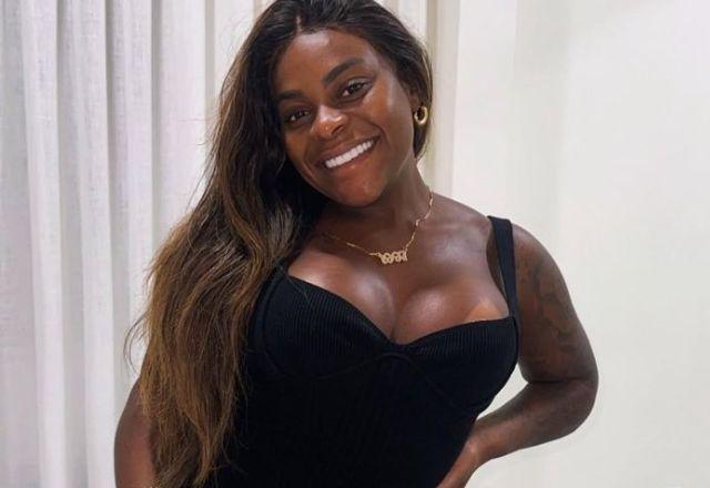 Na foto temos Jojo com cabelo solto alisado, vestido preto e um cordão dourado