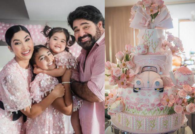 Na foto temos a família completa ao lado do bolo rosa com temática de fusca e flores