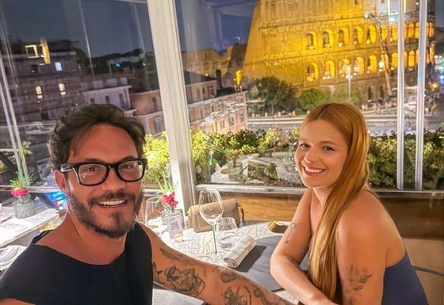 Viih Tube e Eliezer posam em restaurante com o Coliseu ao fundo