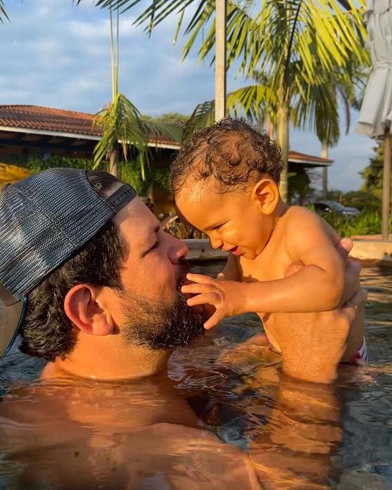 Sorocaba segura o filho, Theo, dentro de uma piscina