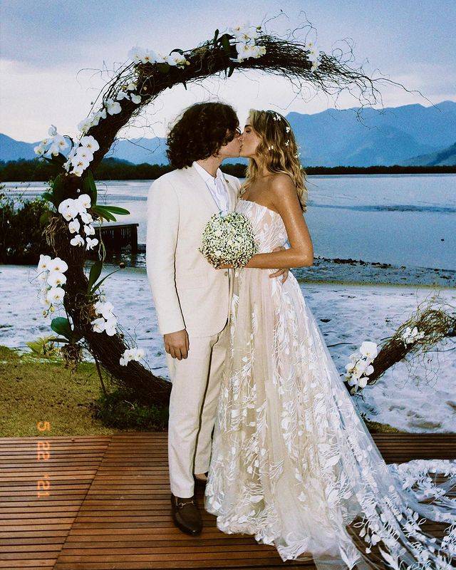 Sasha e João Figueiredo se beijando com o mar ao fundo.