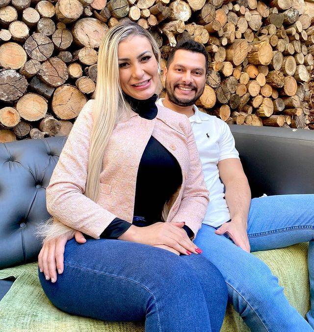 A modelo Andressa Urach e o marido, Thiago Lopes. Os dois aparecem sentados em um sofá.