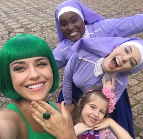 Priscila Sol de Tia Perucas verde, Karin Hills e Bia Arantes de Noviça e Lorena Queiroz de Dulce Maria com uniforme do colégio. Todas em uma selfie sorrindo e alegres