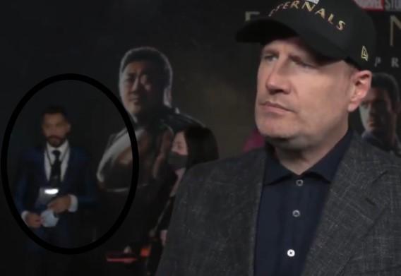 Gil do Vigor aparece de terno azul ao fundo de entrevista de Kevin Feige