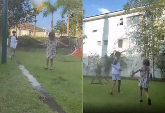 Filhos de Eliana, Arthur e Manuela, brincando no jardim com o irrigador de grama