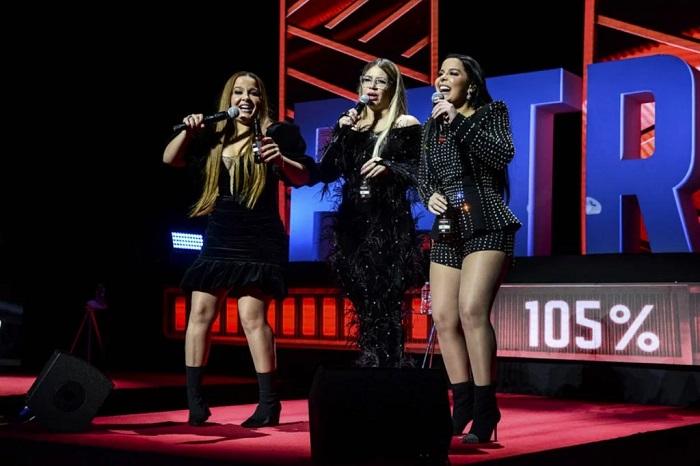 Maiara, Marília Mendonça e Maraisa (nesta ordem), cantando em cima do palco.