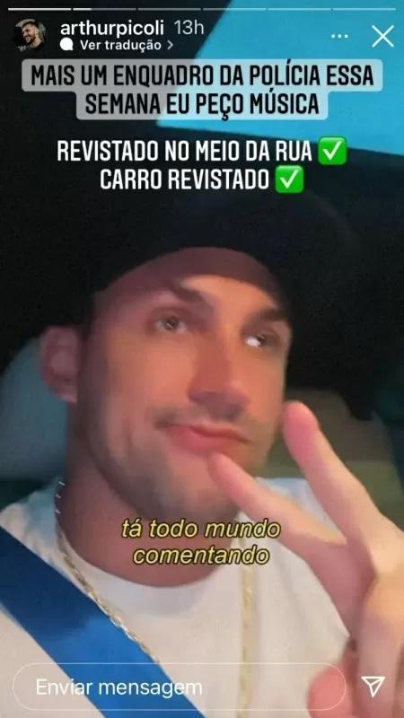 Athur Picole tira selfie dentro do carro, com feição de desdenho. Ele usa uma camiseta branca.