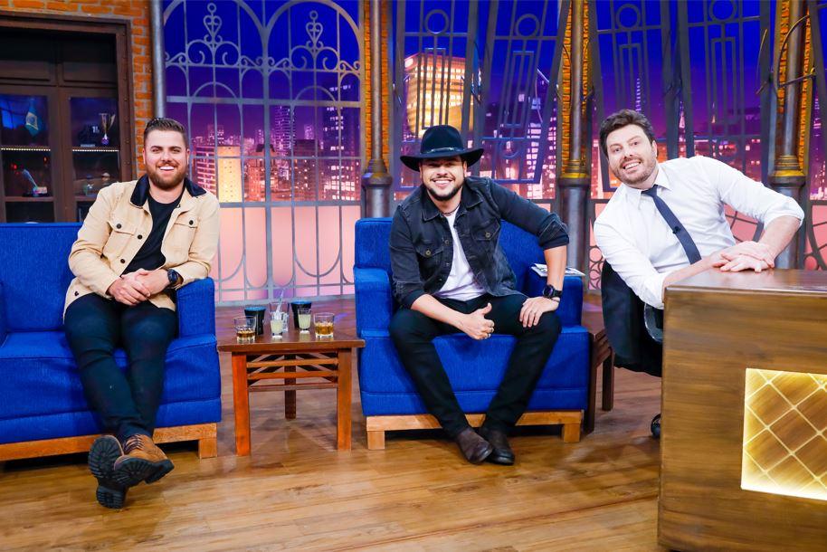 A dupla sertaneja Zé Neto e Cristiano e o apresentador Danilo Gentili posam para foto no palco do The Noite.