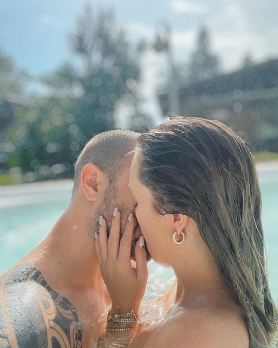 Carla Diaz abraçada e beijando Felipe Becari dentro da piscina