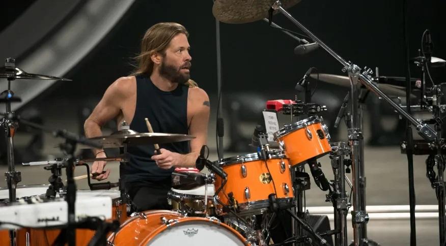 Taylor Hawkins toca bateria em cima de um palco.