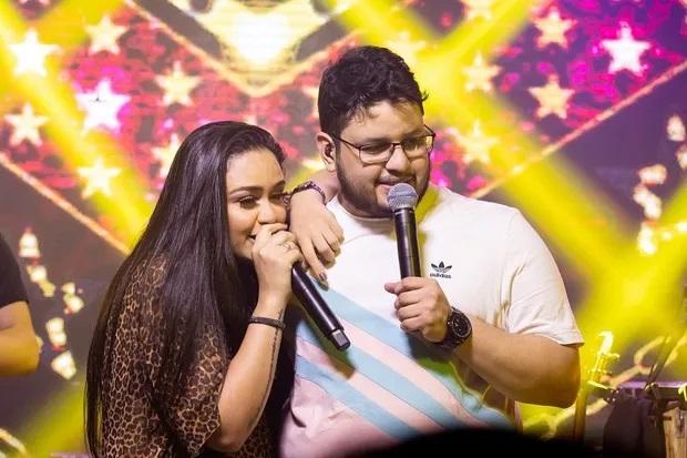 Luiza e Maurílio cantam juntos em cima do palco.