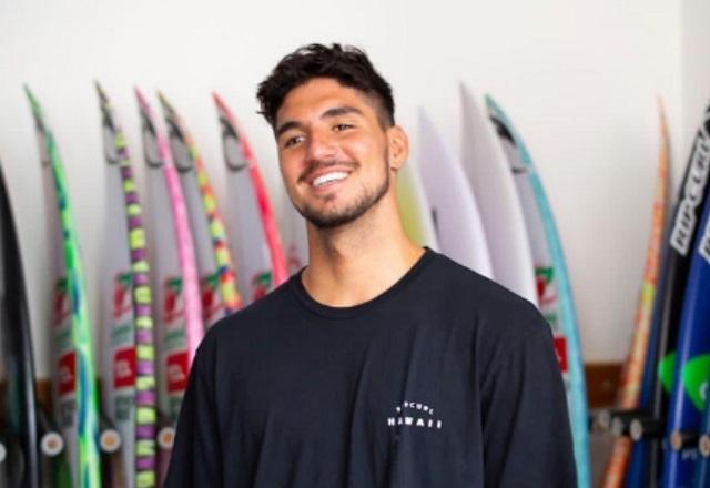 Gabriel Medina sorri para a foto, em meio a pranchas de surf.