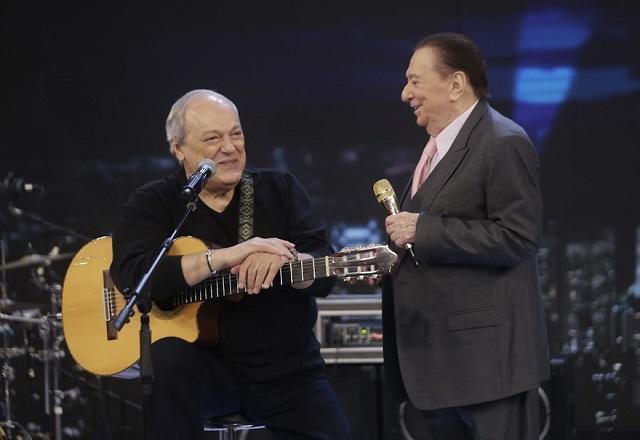 Toquinho sorri enquanto conversa com Raul Gil, no palco.