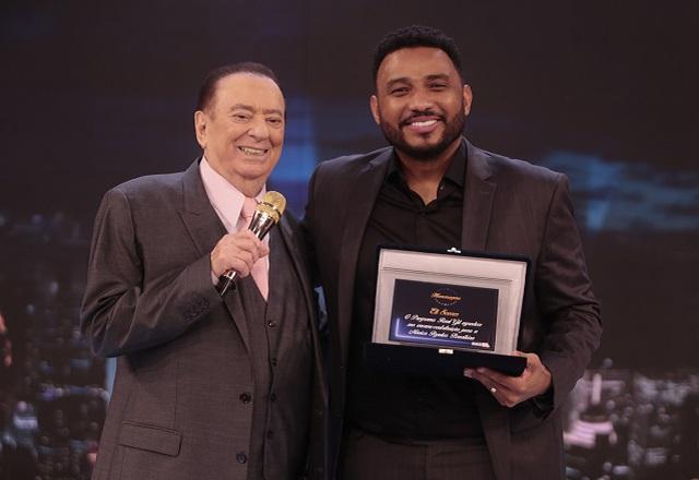 Raul Gil e Eli Soares posam para a foto no palco do programa.