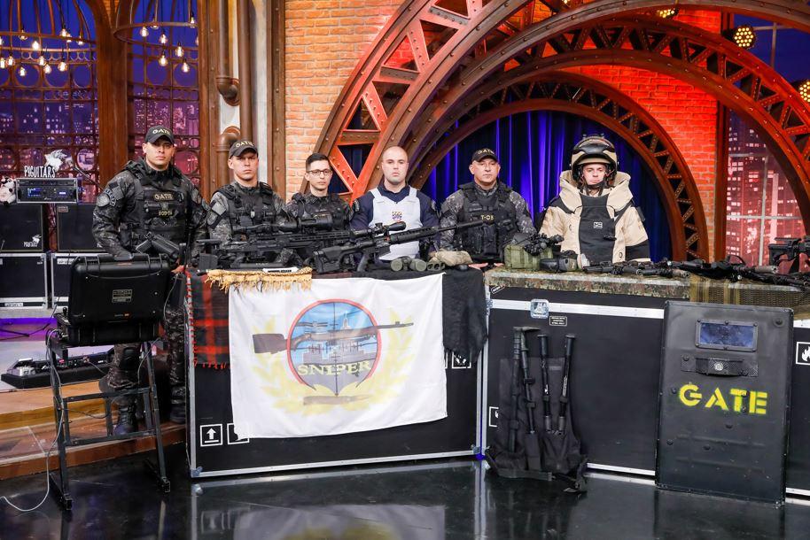 Capitão Pavão, Soldado Gustavo e os convidados do GATE posam para foto.