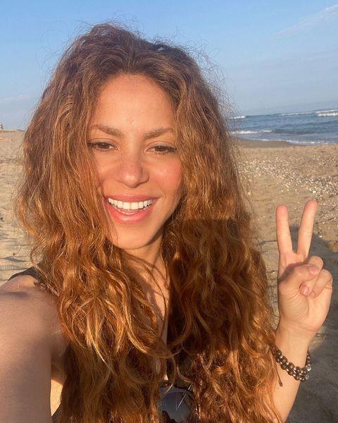 Shakira posando para foto na praia.