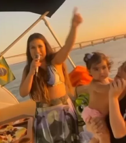 Simone cantando para fãs em barco