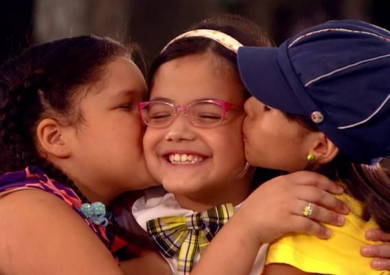 Laura e Alícia beijando as bochechas de Carmen, que está no meio das duas