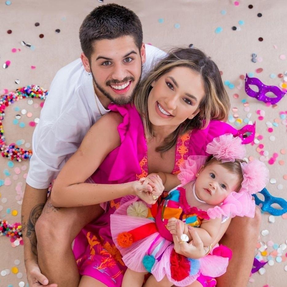 Zé Felipe e Virginia seguram Maria Alice no colo e sorriem para foto.