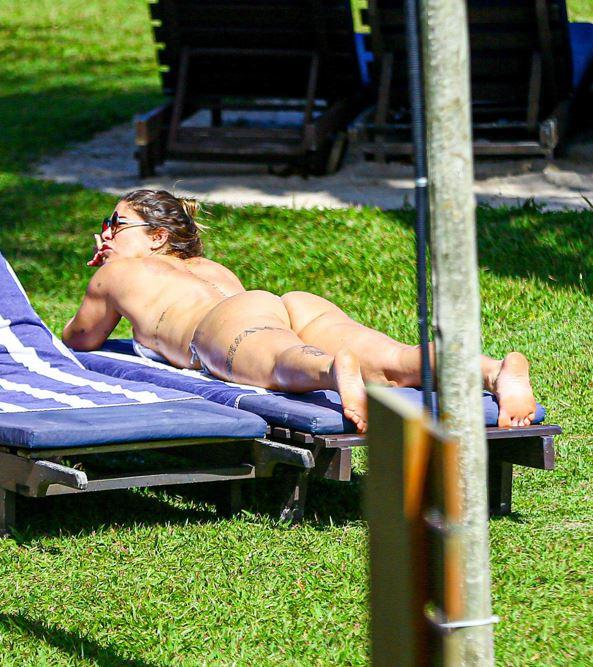 Priscila Fantin e Bruno Lopes tomando sol em cadeira de praia.