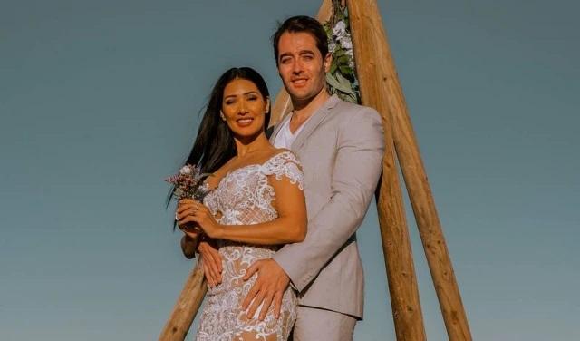 No altar do casamento, Simaria e Vicente Escrig se abraçam e sorriem para a foto.