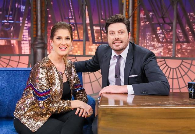 Karina Dohme e Danilo Gentili sorriem enquanto se abraçam, no palco do The Noite