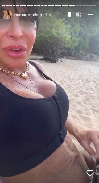 A cantora Gretchen mostrando o umbigo em selfie sentada na praia