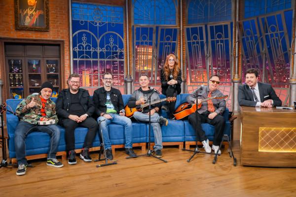 A banda Os Mutantes e Danilo Gentili posam juntos para foto.