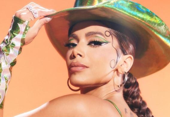 Anitta posa de lado com um chapéu de cowboy 