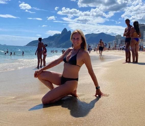 Helô Pinheiro de biquíni ajoelhada na praia de Ipanema